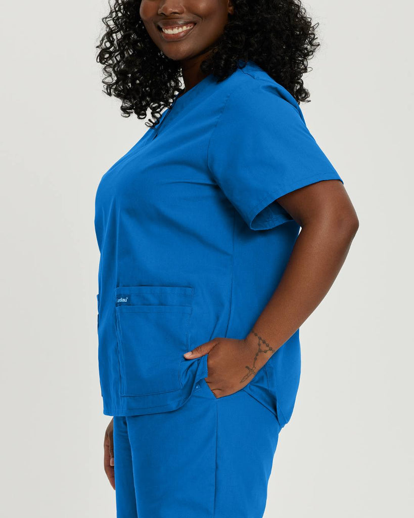 Image of woman in royal blue landau scrubs with four pockets