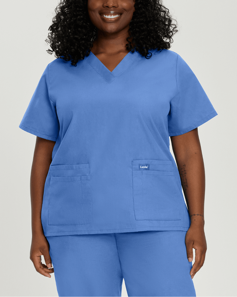 A plus-size woman wearing ceil blue essentials by landau scrubs