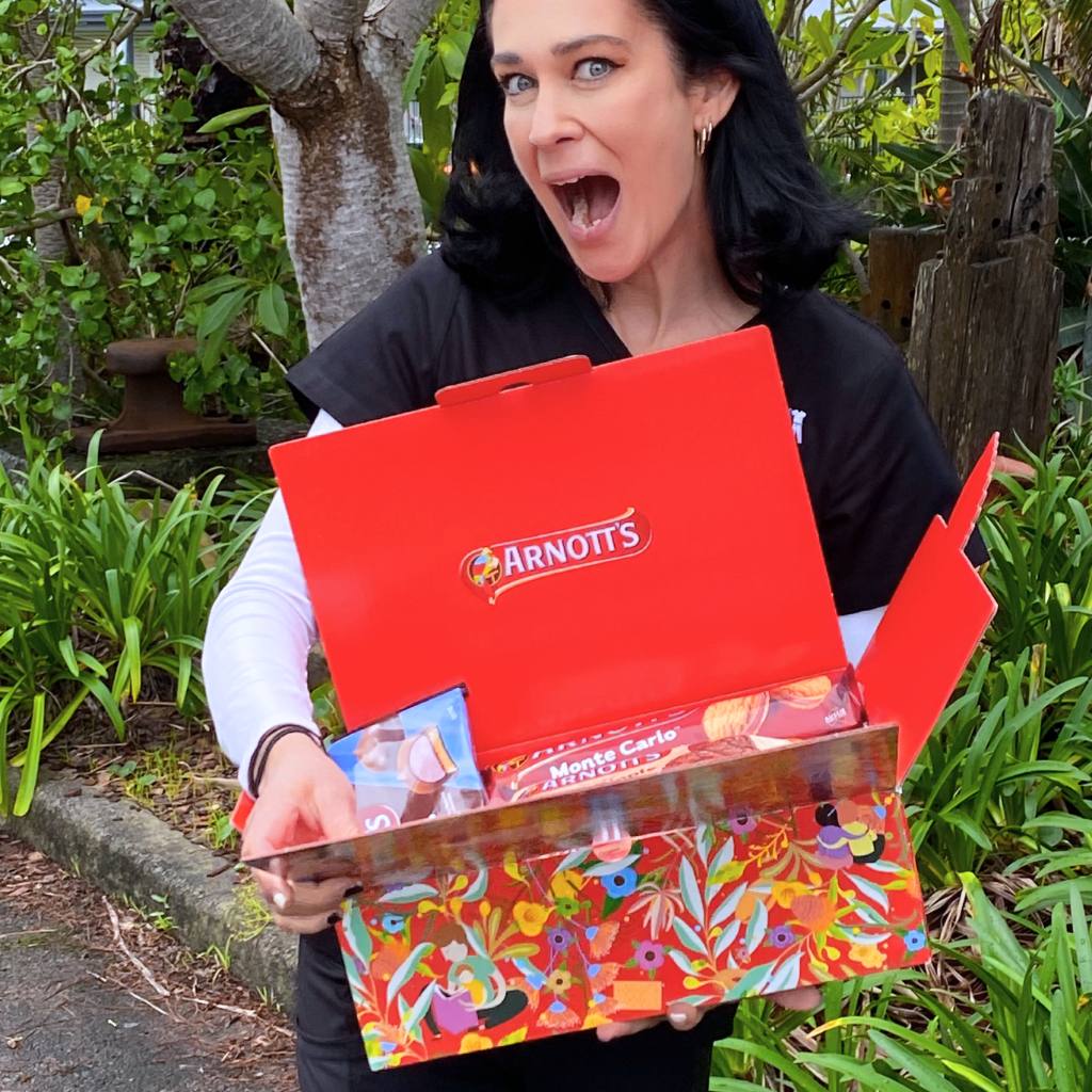 Woman in Scrubs with box of Arnott's Biscuits